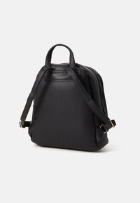 Sac à dos en cuir noir avec un design structuré, des bretelles réglables, une poignée supérieure et des accents en métal doré.