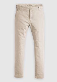 Beige, slim-fit chinos i en bomullsblandning, med dragkedja, bälteshällor och klassisk femfickdesign. Slät textur.