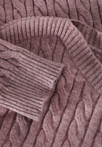 Cable-knit sweater in dusty rose, featuring a textured pattern and ribbed cuffs. Soft material with a cozy, inviting appearance.