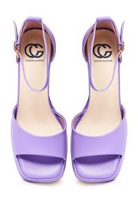 Sandali con tacco alto viola con finitura liscia, ampia fascia frontale, cinturino alla caviglia e design a punta quadrata. Logo sulla soletta.