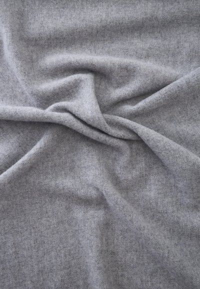Tissu gris clair doux avec une texture lisse montrant de légers plis et rides sur toute la surface.