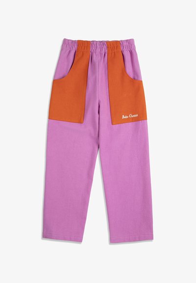 Pantalon pour enfants avec taille élastique, présentant de grandes poches avant orange sur un tissu violet, avec le logo "Bobo Choses" sur la poche droite.