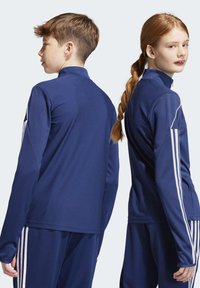 Giubbotti sportivi navy con colli alti, motivi testurizzati e strisce bianche a contrasto sulle maniche. Design aderente per l'abbigliamento attivo.