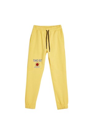Pantalones de chándal amarillos con cintura elástica y cordón negro, que presentan el texto "TIME-OUT" y una gráfica de baloncesto en la pierna izquierda.