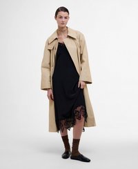 Beige trench coat over a black slip dress with lace trim. Brown ribbed socks and black flat shoes. Minimalist design with loose fit.