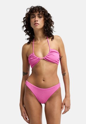 Roze geribbelde bikini met een top met strik aan de achterkant en cupdetails en een bikinibroekje met een lage taille. Gladde textuur met minimale metalen accenten.
