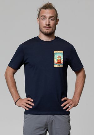 Navy katoenen t-shirt met korte mouwen, met een kleurrijke grafische print op de linker borst die een personage en wolken afbeeldt.