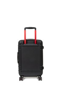 Black hard-shell suitcase with red telescopic handle and wheels. Features a textured surface and integrated side handle for easy lifting.