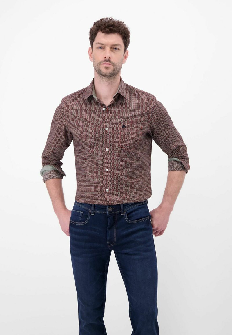 Bruin overhemd met patroon, knoopsluiting, borstzak en contrasterende binnenmanchetten, gecombineerd met donkerblauwe denim jeans.