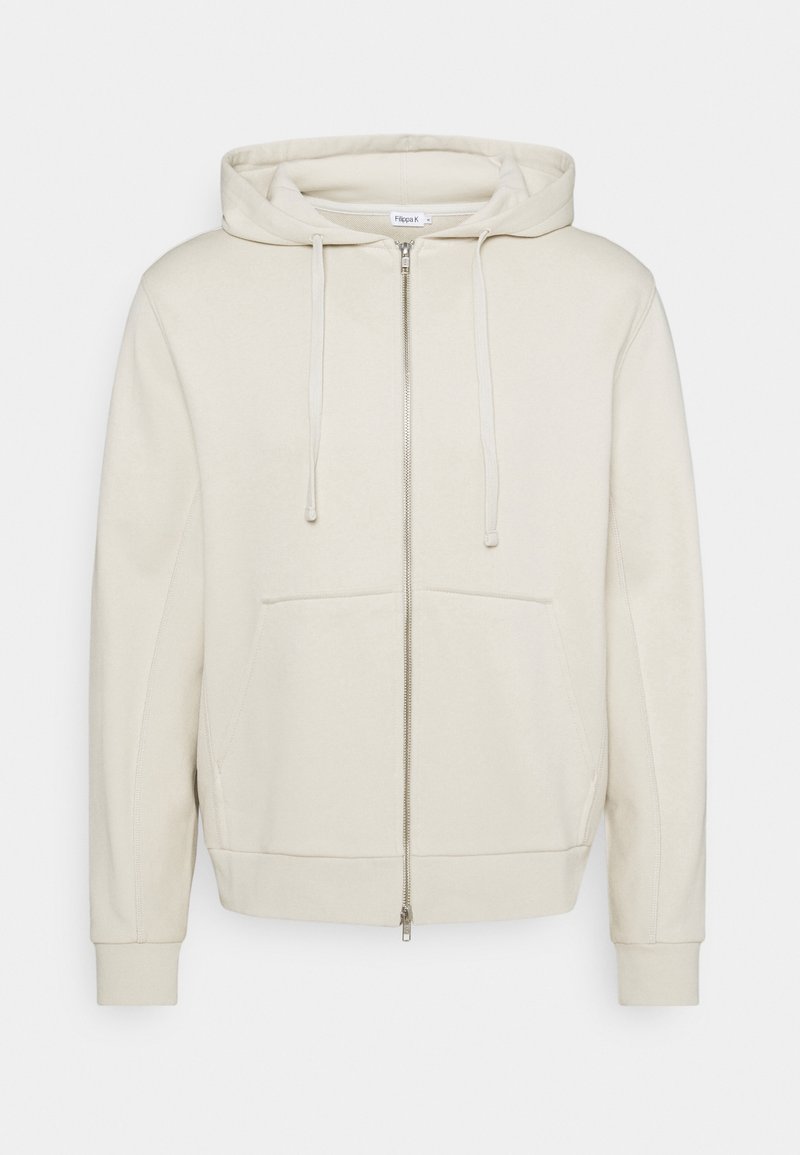 Sweat à capuche beige zippé avec poches avant, capuche à cordon, poignets et bord-côte, présenté sur un fond uni.
