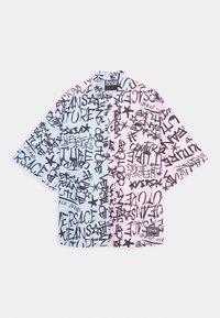 Camisa de botones de manga corta con un diseño dividido; colores azul y rosa con texto en estilo graffiti negro y motivos de estrellas. Material de algodón.
