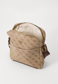 Sac bandoulière en tissu à motifs marron avec quincaillerie dorée, extérieur texturé, fermeture éclair et doublure intérieure beige avec motif logo.