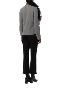 Black and white striped knit sweater paired with black straight-leg jeans and chunky heeled black boots, viewed from the back.
