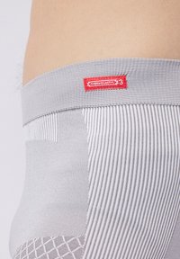 Intimo termico grigio con una cintura testurizzata con branding rosso, e motivi a strisce diagonali e a rombi sul tessuto.