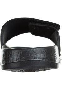 Sorte sandaler med flad sål, tekstureret overrem og polstret ryg. Designet er minimalistisk med en glat finish.