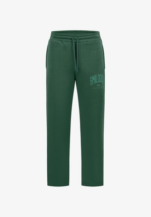 Pantalones deportivos verde oscuro con cintura elástica, cordón, bolsillos laterales y "SMILODO" impreso en la parte superior del muslo izquierdo.