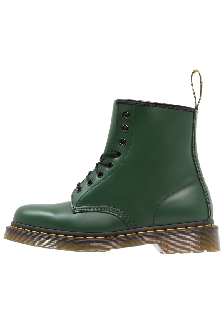 Zielona skórzana botka za kostkę z czarnymi akcentami, okrągłym noskiem, sześcioma oczkami, żółtym przeszyciem, trwałą podeszwą i pętlą do zakładania z tyłu.