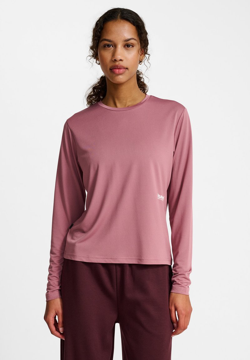 Long-sleeve, crew-neck shirt in mauve, textured fabric. Features a small logo on the lower side and relaxed fit, paired with dark maroon trousers.