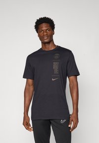 Černé tričko s krátkým rukávem a kulatým výstřihem, s potiskem loga Paříže a zlatým swoosh logem Nike. Vyrobeno z hladké bavlněné směsi.