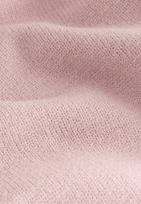 Světle růžová látka s texturovaným pleteným vzorem, která ukazuje jemné vlákna a mírně chlupatý povrch. Žádné viditelné vzory nebo akcenty.