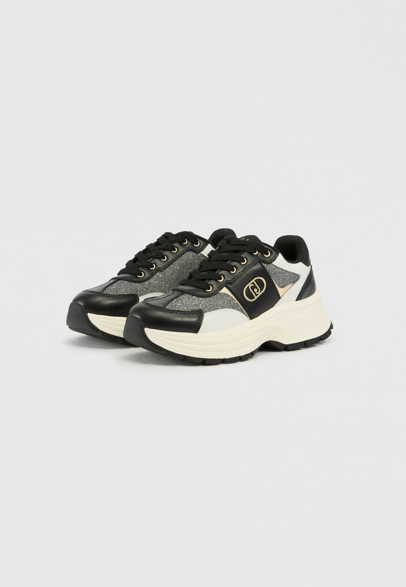 Schwarze und silberne Sneaker mit strukturiertem Obermaterial, runder Zehenpartie und dicker weißer Sohle. Verfügt über goldene Ösen und ein Logo-Highlight an der Seite.