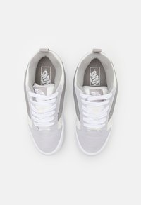 Graue und weiße Sneaker mit einem Obermaterial aus Wildleder und Canvas, ausgestattet mit weißen Schnürsenkeln, einem gepolsterten Kragen und einem Vans-Logo auf der Zunge.