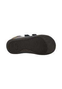 Sola di sandalo blu navy per bambini con grip in gomma nera testurizzata e cinturini regolabili, nome del marchio visibile sulla suola e sul cinturino.
