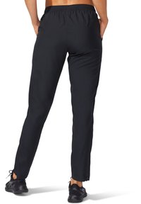 Zwarte sportbroek met een elastische tailleband, slim fit en ritsen bij de enkels. Gemaakt van lichtgewicht stof, ontworpen voor comfort en mobiliteit.