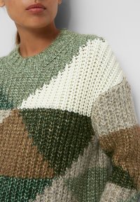 Sweter dzianinowy w kolorze zielonym, beżowym i białym. Posiada geometryczny wzór z różnymi fakturami. Okrągły dekolt z ściągaczem.