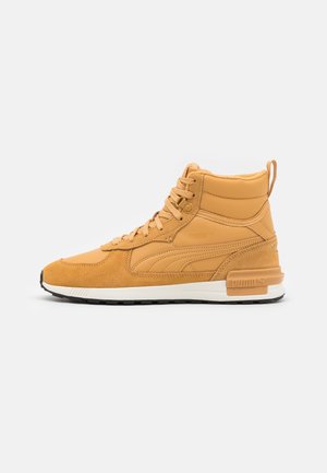 Beżowy, wysoki sneaker z panelami z zamszu i skóry, z przodu sznurowany, z wyściełanym kołnierzem i białą gumową podeszwą z czarnym bieżnikiem.