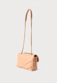 Bolsa de pele acolchoada bege com corrente dourada e seção de ombro almofadada, inclinada para mostrar os detalhes laterais e frontais.