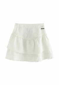 Hvid lagdelt nederdel med broderet mønster, der har et tekstureret toplag og en flæset bund, afsluttet med et lille metallogo.