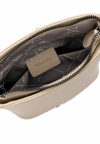 Borsa beige con texture e apertura a zip, dotata di una fodera interna patterned in grigio scuro e di una piccola etichetta con il marchio all'interno.