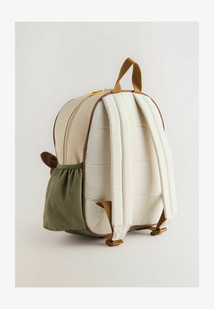 Beige- und grüne Rucksack mit runder Form, Stoffaußenmaterial, braunen Akzenten, gepolsterten Trägern und einer Seitentasche. Sichtbare, detaillierte Stickerei.