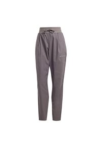 Grå, lätta byxor med dragsko i midjan, avsmalnande ben och en broderad logotyp på den nedre sidan. Slät textur, avslappnad design.