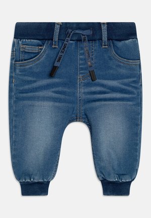 Blaue Jeanshose für Kleinkinder mit elastischem Bund und Bündchen, Vorderentaschen und einem marineblauen Kordelzug mit aufgedrucktem Text.