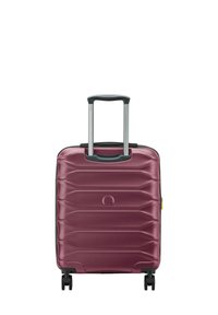 Valigia rigida di un profondo bordeaux, con un design a zigzag testurizzato, manico retrattile e quattro ruote nere per la mobilità.