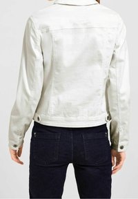 Chaqueta de mezclilla gris claro con cuello, puños abotonados y bolsillos traseros, con un corte recto y textura suave. Diseño ajustado.