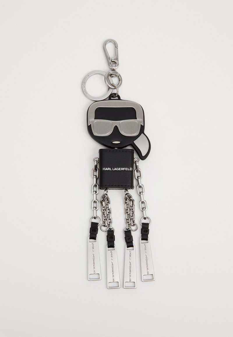 Acessório de chaveiro em forma de figura de silicone preta com óculos de sol, acabamentos em metal prateado e quatro cadeias penduradas com etiquetas retangulares.