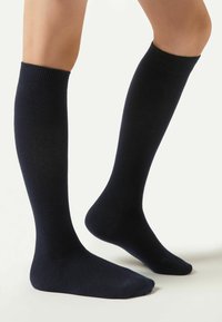 Mørkeblå, knæhøje sokker lavet af blødt, struktureret stof, med ribbede manchetter og glatte fodbetræk, i et enkelt design.