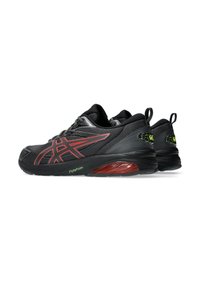 Baskets de sport noires avec une tige en maille texturée, des accents rouges et une semelle rembourrée intégrant la technologie FlyteFoam et un logo réfléchissant.