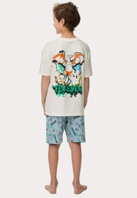 Witte katoenen T-shirt met kleurrijke Pokémon-afbeelding op de achterkant, gecombineerd met lichtblauwe shorts met Pikachu-patronen.