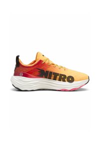 Zapatilla de running con un upper texturizado en amarillo-naranja, acentos negros y un destacado logo "NITRO". Suela intermedia blanca ligera y acolchada con detalles en rosa.