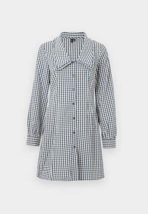 Haljina s plavim i bijelim gingham uzorkom, koja se ističe velikim ovratnikom, dugim puf rukavima i prednjim kopčanjem na dugmad. Napravljena od mekog pamučnog materijala.