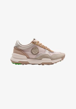 Zapatilla deportiva beige y rosa claro con cordones delanteros, suela texturizada y detalle de parche circular cosido en el lateral.