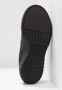 Svart sneaker med texturerad gummisula, ribbade mönster och logotypdetalj. Slank, låg profil design, lämplig för vardagsbruk.