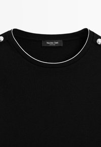 Top noir col rond avec détails en passepoil blanc le long de l'encolure et boutons argentés à l'épaule, étiqueté Massimo Dutti.