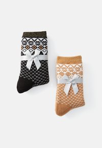 Δύο ζευγάρια πλεκτών κάλτσων σε μαύρο και χρυσό, καθώς και πορτοκαλί και λευκό, η καθεμία με γεωμετρικό μοτίβο και μια ασημένια κορδέλα.