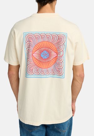 Cream cotton t-shirt featuring a large graphic on the back with a central orange eye design, surrounded by pink, red, and blue swirls.
