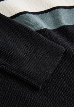 Mustast soonikustrikkist kampsun tekstuuriga viimistlusega, millel on tekstiili ulatuses horisontaalsed triibud kreemjas, helesinises ja tumerohelises värvitoonis.